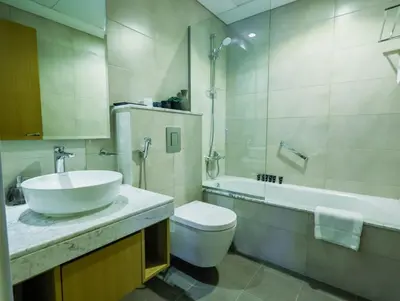 a bathroom with a sink and a toilet and a tub at Palm Mirage Holiday Homes-2BR With Burj Alarab and City view in Dubai