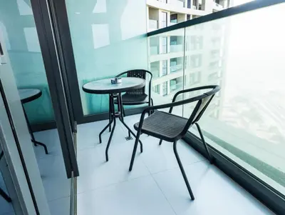 a table and chairs on the balcony of a building at Palm Mirage Holiday Homes-2BR With Burj Alarab and City view in Dubai