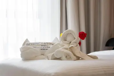 a towel angel sitting on top of a bed at Ultra Luxuary 2BR - Creek Beach - Serenity Living in Dubai
