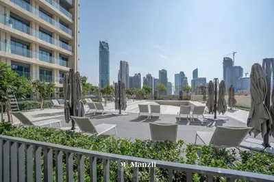 a patio with chairs and tables and umbrellas at Luxury 2BR Apartment in Downtown with Full Burj Khalifa View in Dubai