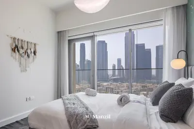 a bedroom with a large window with a city view at Luxury 2BR Apartment in Downtown with Full Burj Khalifa View in Dubai