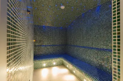a sauna with blue tiled walls and a blue tub at Bespoke Holiday Homes - Luxury 2BR with Stunning Marina Views in LIV Marina in Dubai