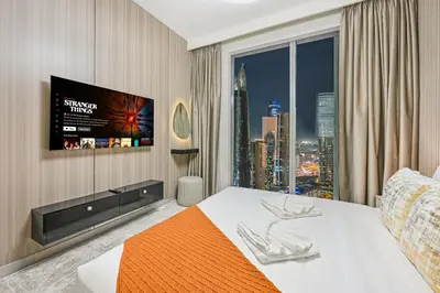 a hotel room with a bed and a large window at Luxury 2BR in Downtown 35th Floor 5 min walk Dubai Mall, Gym,Pool, 500mbps Wifi, Forte Tower in Dubai