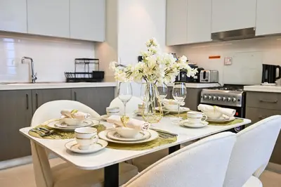 a white table with white chairs and a table with flowers at Luxury 2BR in Downtown 35th Floor 5 min walk Dubai Mall, Gym,Pool, 500mbps Wifi, Forte Tower in Dubai