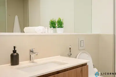 a bathroom with a sink and a toilet with a mirror at Brand New Modern 2 BR Retreat in Dubai Creek Harbour in Dubai