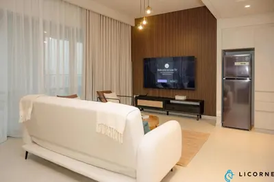 a living room with a white couch and a tv at Brand New Modern 2 BR Retreat in Dubai Creek Harbour in Dubai