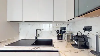 a kitchen with a sink and white cabinets at The Point - One Bed with Marina Skyline Views in Dubai