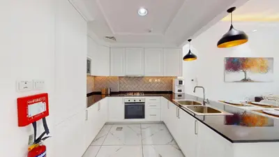 a kitchen with white cabinets and a sink at Al Ghaf - Upgraded One Bed with Pool View in Arjan in Dubai