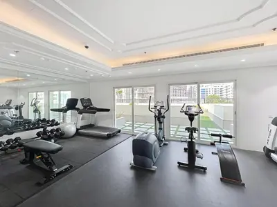 a gym with treadmills and exercise equipment in a room at Al Ghaf - Upgraded One Bed with Pool View in Arjan in Dubai