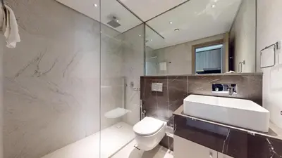 a bathroom with a sink and a toilet and a shower at Oxford Boulevard - Vibrant Studio in JVC in Dubai