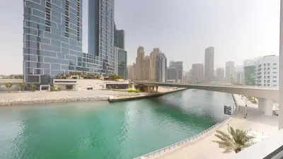 a river in the middle of a city with tall buildings at 5242 Tower 2 - One Bed, Low Floor with Canal View in Dubai