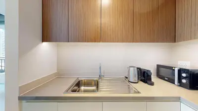 a kitchen with a sink and a microwave at 5242 Tower 2 - One Bed, Low Floor with Canal View in Dubai