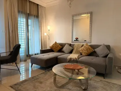 a living room with a couch and a glass table at ASHRI Luxury apt Steps to Dubai Mall & Burj Khalifa in Dubai