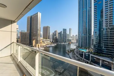 a view of a river from a balcony in a city at Dubai Marina Waterfront Stay with Maid Room in Dubai