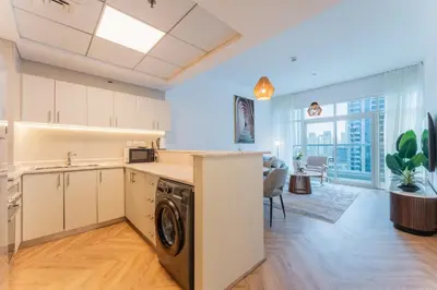 a kitchen and living room with a washer and dryer at Dubai Marina Waterfront Stay with Maid Room in Dubai