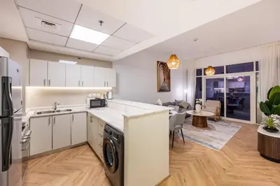 a kitchen with a washer and dryer and a living room at Dubai Marina Waterfront Stay with Maid Room in Dubai