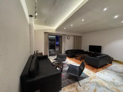 a living room with a black couch and chairs at Stylish 1BR JBR Beachfront in Dubai