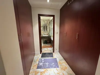a hallway with a bathroom with brown doors and a rug at Stylish 1BR JBR Beachfront in Dubai
