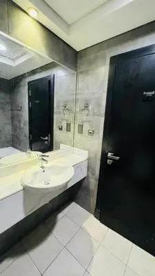 a bathroom with a sink and a black door at Modern Homestay Oval Tower, Business Bay in Dubai