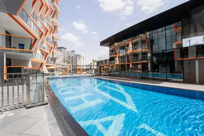 a swimming pool in front of a building at Designer Suite with Skyline views in Dubai