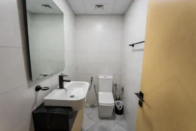 a bathroom with a sink and a toilet and a mirror at Designer Suite with Skyline views in Dubai
