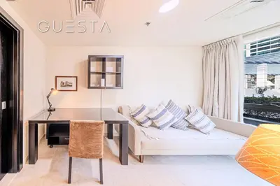a living room with a table and a couch at Al Majara 1 BDR plus Guest Bedroom, Dubai Marina in Dubai