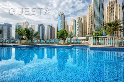 a large swimming pool in front of a city at Al Majara 1 BDR plus Guest Bedroom, Dubai Marina in Dubai
