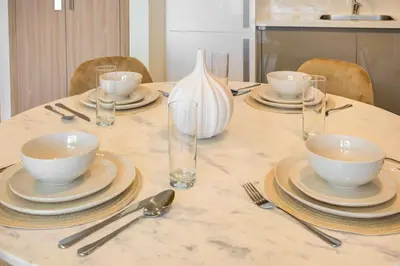 a table with plates and bowls and silverware on it at TRPS - Farhad Azizi, Al Jaddaf - Premium 1BR, Furnished with Pool View in Dubai