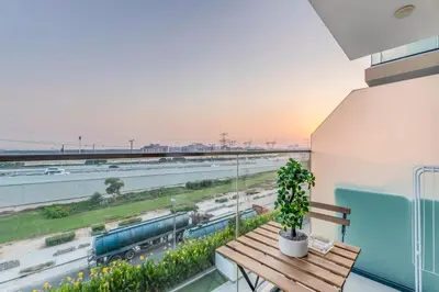 a balcony with a wooden bench and a train track at Luxury Apartments in Meydan in Dubai