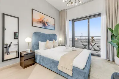 a bedroom with a blue bed and a large window at Luxury Apartments in Meydan in Dubai