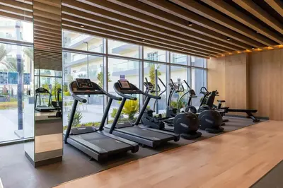a gym with a row of tread machines in a room at Bella Casa - Luxury 1BR Apartment - Brand New Furniture in Dubai