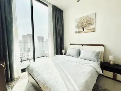 a bedroom with a bed and a large window at Fully Equipped Studio with Kitchen and Free Wi-Fi in Dubai
