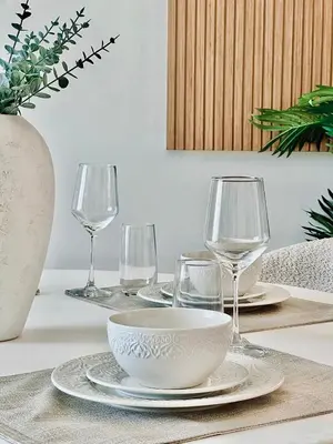 a table with plates and wine glasses on it at Cloud Level 1BR Calm with Parking Pool & Gym in Dubai