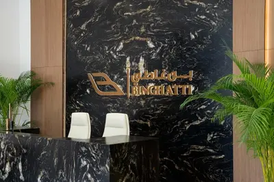 a lobby with two chairs and a sign on a wall at Chic 1BR with free Pool & Gym - Near Mall of Emirates in Dubai