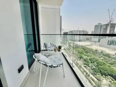 a balcony with two chairs and a view of a city at Chic 1BR with free Pool & Gym - Near Mall of Emirates in Dubai
