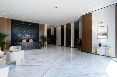 a lobby with a large marble floor and a reception desk at Chic 1BR with free Pool & Gym - Near Mall of Emirates in Dubai