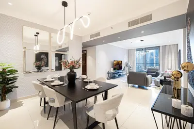 a dining room and living room with a table and chairs at Boulevard Point 3BR plus Maid Direct Access to DXB Mall in Dubai