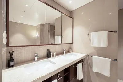 a bathroom with two sinks and a large mirror at Boulevard Point 3BR plus Maid Direct Access to DXB Mall in Dubai