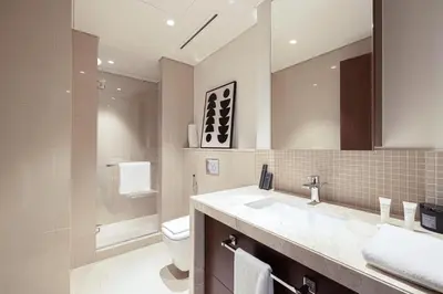 a bathroom with a sink and a toilet and a mirror at Boulevard Point 3BR plus Maid Direct Access to DXB Mall in Dubai