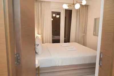 a bedroom with a white bed and a mirror at Live the Opulenco Experience! 2BR Urban Oasis by Missoni, Business Bay in Dubai