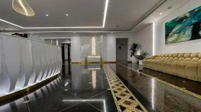 a lobby with a couch and a painting on the wall at FIRST CLASS 1BR High Floor Luxury & Palm View in Dubai