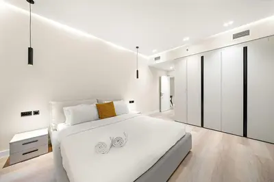 a white bedroom with a large bed and white cabinets at FIRST CLASS 1BR High Floor Luxury & Palm View in Dubai