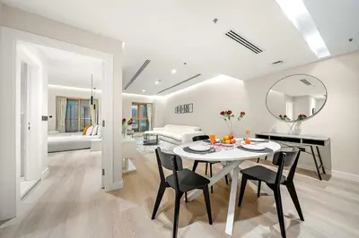 a dining room and living room with a table and chairs at FIRST CLASS 1BR High Floor Luxury & Palm View in Dubai