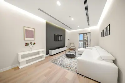 a white living room with a white couch and a tv at FIRST CLASS 1BR High Floor Luxury & Palm View in Dubai
