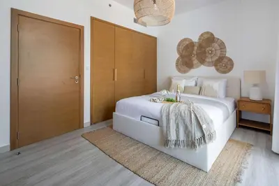 a bedroom with a white bed and a wooden door at Frank Porter - Claren Tower 2, Downtown in Dubai