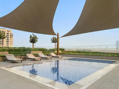 a swimming pool with lounge chairs and a building at FIRST CLASS 1BR Luxe Living with a View in Dubai