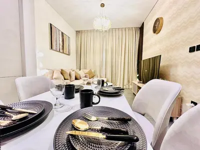 a dining room with a white table and chairs at Modern 02 Bedroom in Sobha Crest B in Dubai