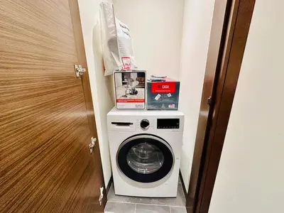 a washing machine with boxes on top of it in a room at Modern 02 Bedroom in Sobha Crest B in Dubai