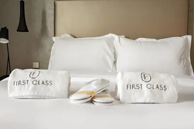 a bed with two first class towels and two shoes at FIRST CLASS 2BR Mesmerizing Burj Khalifa View in Dubai