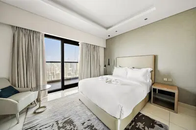 a hotel room with a large bed and a chair at FIRST CLASS 2BR Mesmerizing Burj Khalifa View in Dubai